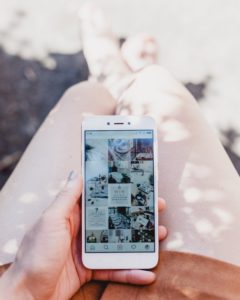 Chica sosteniendo un móvil con la aplicación instagram abierta